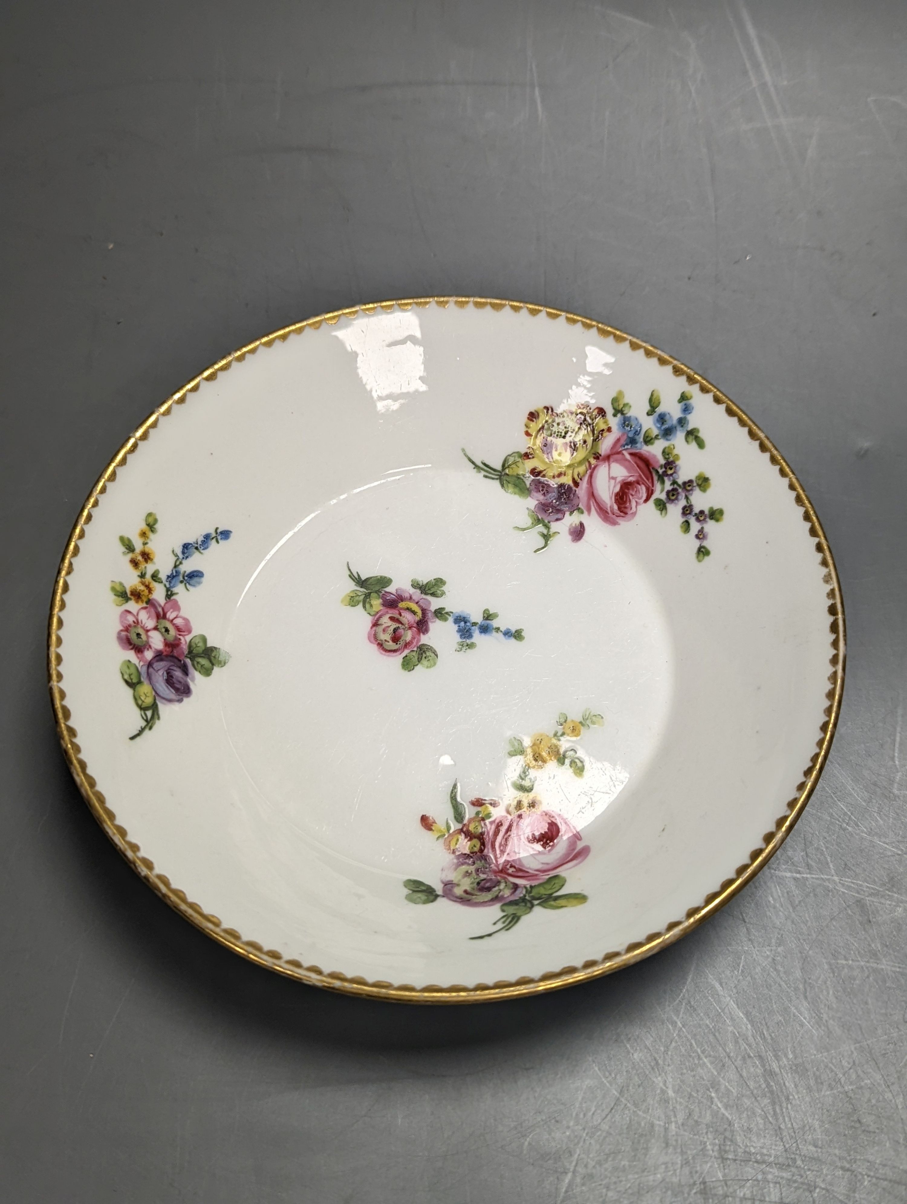 A Sevres tapering cup with entwined handle and cover and stand painted with flowers, date code for 1780, painters mark for Le Bel jnr., square incised marks, height 10.5cm